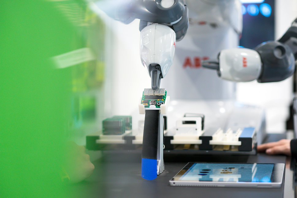 Der Robotergreifer von YuMi, platziert einen Chip auf einer Ablage.