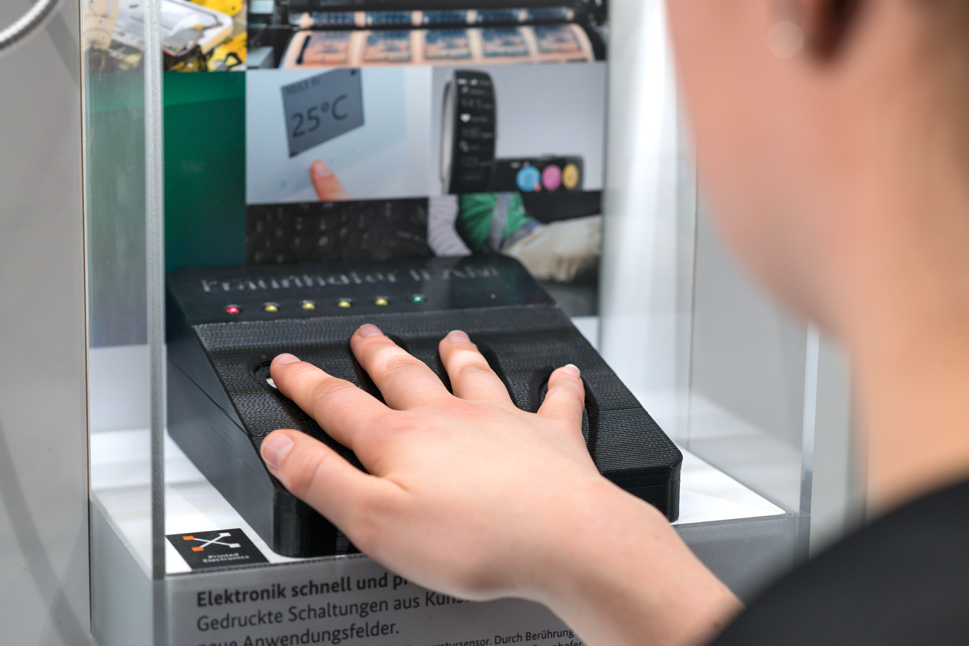 Eine Frau legt ihre Hand auf eine gedruckte, schwarze Platte.