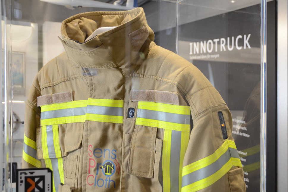 Eine Feuerwehrjacke mit elektronischem Sensortextil in einer Vitrine im InnoTruck.